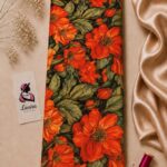 Bold orange floral design with lush green leaves on a deep black background-Italian Silk (ST01)