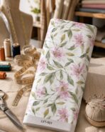 soft pink lily floral design with sage green leaves on an ivory background