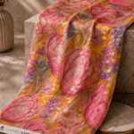 Luxurious chiffon zari fabric with large pink florals, soft lavender accents, and shimmering gold details on a warm golden background-Italian Chiffon Zari (ZR16)