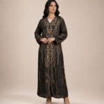 Black abaya featuring an abstract dotted pattern in warm beige tones, arranged in elegant vertical detailing.