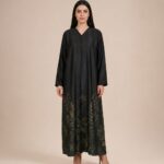 Elegant abaya featuring subtle botanical leaf motifs in deep olive and gold tones, beautifully concentrated along the lower hem.