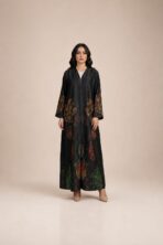 Flowing abaya adorned with vibrant abstract motifs in orange, red, and green tones, concentrated along the sleeves and lower part.