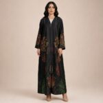 Flowing abaya adorned with vibrant abstract motifs in orange, red, and green tones, concentrated along the sleeves and lower part.