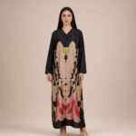 Statement abaya featuring a bold symmetrical floral-inspired print in soft beige, blush pink, red, and olive tones.
