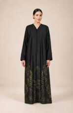⁦Elegant abaya featuring subtle botanical leaf motifs in deep olive and gold tones, beautifully concentrated along the lower hem.⁩ - الصورة ⁦3⁩