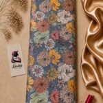 Charming botanical design featuring richly detailed flowers in peach, mustard, sage green, and cream on a muted blue background - Silk Jacquard (JD02)