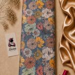 Charming botanical design featuring richly detailed flowers in peach, mustard, sage green, and cream on a muted blue background - Silk Jacquard (JD02)