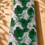 Artistic floral print featuring rich emerald-green blooms with watercolor details on a soft ivory and grey background.