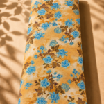 Artistic floral design with striking blue blossoms and vintage brown foliage over a textured golden background.