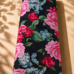 Dramatic floral design featuring lush pink and red roses with delicate blue blossoms and rich green leaves on a deep black background - SWISS COTTON (PC01)
