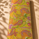 Vibrant paisley design filled with intricate floral details in pink, orange, and green on a bright golden-yellow background - SWISS COTTON (PC01)