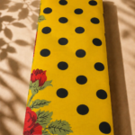 Bright yellow cotton with bold black polka dots and vibrant red floral accents - Spanish Cotton (PC11)