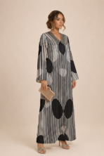 Striking black and white abaya featuring fine vertical stripes with bold oversized polka dots for a modern geometric look
