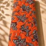 Vibrant orange chiffon with bold spotted floral motifs in black, white, and deep brown - Italian Chiffon (CF01)