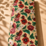 Warm beige chiffon with rich red and pink florals, white blossoms, and vibrant green leaves - Italian Chiffon (CF01)