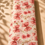 Ivory chiffon adorned with elegant coral bow motifs, delicate florals, and warm golden leafy branches - Italian Chiffon (CF01)