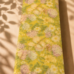Bright yellow chiffon adorned with delicate ivory and blush florals, soft hydrangea clusters, and fresh green leaves - Italian Chiffon (CF01)