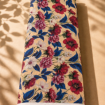 Warm beige chiffon adorned with rich burgundy and pink florals, soft white blossoms, and striking royal blue leaves - Italian Chiffon (CF01)