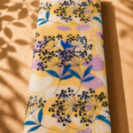 Soft yellow cotton with delicate black botanical florals, vibrant blue leaves, and subtle lavender accents - Italian Cotton (PC02)