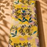 Bright yellow cotton with delicate black botanical florals, teal leaves, and soft blush accents - Italian Cotton (PC02)