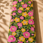 Black cotton featuring vibrant pink and golden-yellow flowers with lush green foliage in a bold floral pattern - Italian Cotton (PC02)