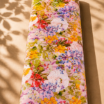 Soft pink cotton featuring a rich garden-inspired floral print with white, yellow, red, and blue blossoms, accented by fresh green foliage - Italian Cotton (PC02)