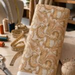 Elegant fabric featuring a soft neutral paisley print with warm beige tones.