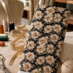 Elegant floral fabric featuring soft beige blooms on a deep black background.