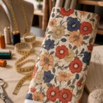 Elegant floral print featuring bold red, navy and peach blooms with soft neutral foliage.