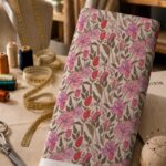 Soft pink and red florals with delicate green leaves on a warm ivory background.