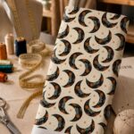 Celestial moon print with floral details and warm earthy accents on a soft cream background.