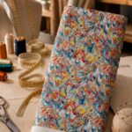 Vibrant marbled pattern with fluid swirls of blue, coral, orange, yellow, and soft pink, creating an artistic and energetic look.