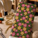 Bold pink and golden-yellow blossoms surrounded by lush green foliage on a deep black background, creating a vibrant vintage-inspired look.