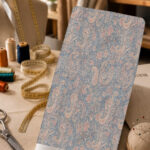 Delicate paisley pattern in soft blue, blush pink, and cream tones.