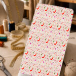 Playful celestial print with red crescent moons, colorful stars, and delicate swirling accents on a soft cream background.