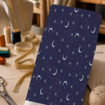 Elegant celestial print with soft crescent moons, delicate stars, and tiny dots on a deep navy background.