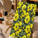 Vibrant yellow floral print with muted olive-green leaves on a deep dark background.