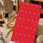 Vibrant red geometric print with repeating magenta diamond and petal motifs.