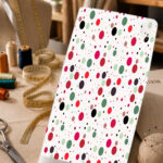 Playful red, pink, green, and black polka-dot print on a clean white background.
