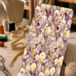 Soft painterly floral print in lavender, ivory, cream, and muted purple tones with subtle golden accents.