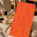 Vibrant pink floral and leafy pattern on a bold orange background.