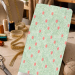 Coral polka dots on a soft mint-green textured background.