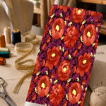 Bold coral-red floral print with purple foliage on a deep dark background.