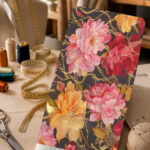 Luxurious pink, red, and golden floral print with elegant gold chain accents on a dark background.