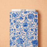Elegant porcelain-inspired botanical design featuring intricate cobalt and soft blue flowers with graceful winding leaves on a warm ivory background.