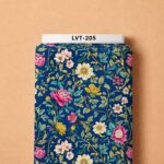 Vibrant pink, ivory, and golden blooms intertwined with graceful green foliage on a rich royal blue background.