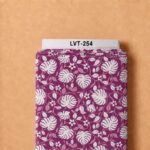 Tropical botanical print with bold ivory leaves, delicate blush foliage, and small flowers on a rich berry-purple background.