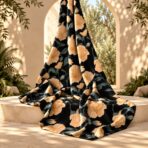 ⁦Elegant floral design featuring warm peach blooms with muted sage-green leaves on a deep black background.⁩ - الصورة ⁦2⁩