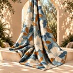 ⁦Elegant ivory floral print with deep blue and warm amber leaves on a soft dusty blue background.⁩ - الصورة ⁦2⁩