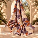 ⁦Elegant ivory floral print with deep plum and warm amber leaves on a soft mauve background.⁩ - الصورة ⁦2⁩
